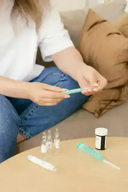 거실 소파에 앉아 인슐린 주사기를 준비하는 보호자의 모습